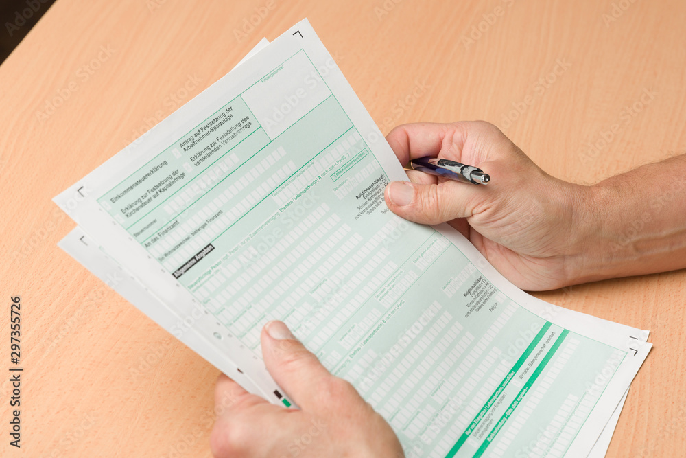 Obraz premium hand witha pen holds of tax forms for last year tax declaration