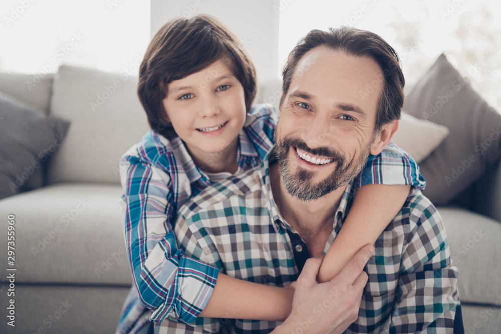 Close-up portrait of two nice attractive lovely tender cheerful cheery guys dad daddy and pre-teen son cuddling hugging at light white modern style interior house living-room indoors Close-up portrait of two nice attractive lovely tender cheerful cheery guys dad daddy and pre-teen son cuddling hugging at light white modern style interior house living-room indoors