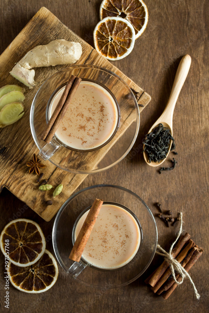 Traditional Indian masala chai tea and ingredients on wooden background. Hot drink of milk and tea with spices. Copy space, top view. Close up. Traditional Indian masala chai tea and ingredients on wooden background. Hot drink of milk and tea with spices. Copy space, top view. Close up.