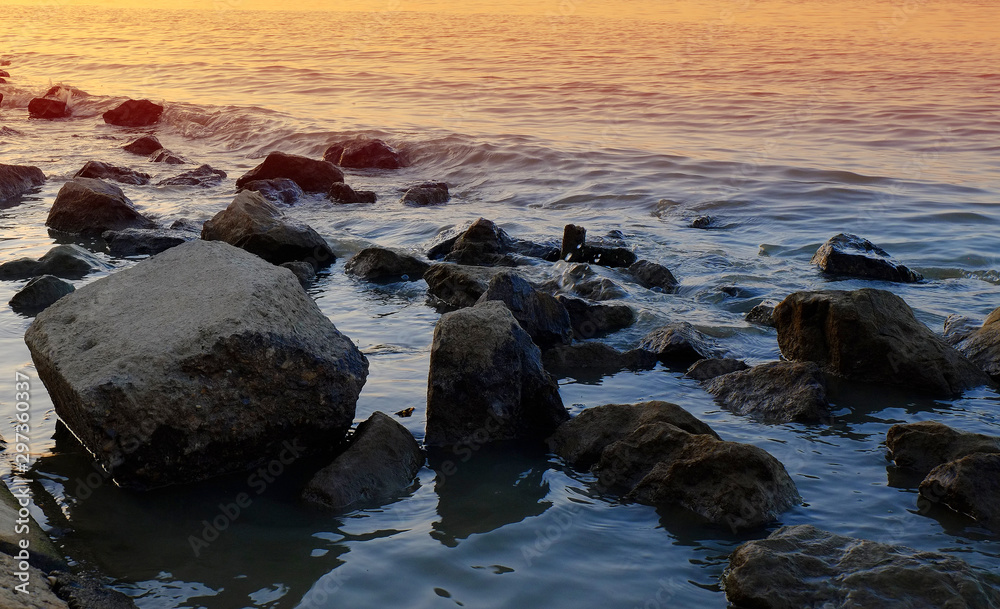 Fototapeta premium Rocks in shalow water in a sunset