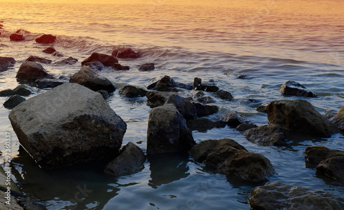 Rocks in shalow water in a sunset