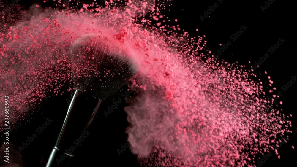Super slow motion of makeup brush with falling pink powder, black background. Filmed on high speed cinema camera, 1000fps.