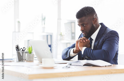 Concentrated african american man working with laptop in office