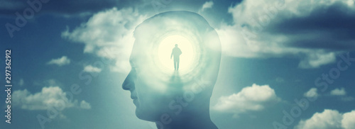 A silhouete of a man with rays of light emanating from the brain as a symbol of the power of thinking. Concept on the topic of psychiatry (bipolar disorder, schizophrenia), psychology, religion etc. photo