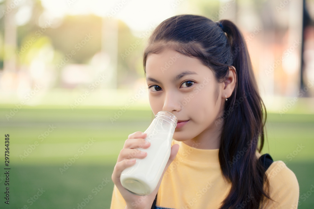 An Asian girl is drinking a delicious bottle of milk. An Asian girl is drinking a delicious bottle of milk.