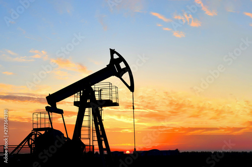 Oil drilling derricks at desert oilfield. Crude oil production from the ground. Oilfield services contractor. Oil drill rig and pump jack. Petroleum production, natural gas, liquids, NGL, additive. photo