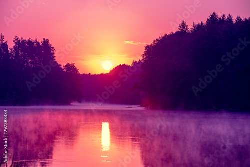 Fototapeta Naklejka Na Ścianę i Meble -  Magical sunrise over the lake with a beautiful reflection on the water. Serene lake in the early morning. Nature landscape
