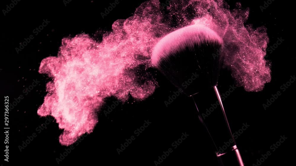 Super slow motion of makeup brush with falling pink powder, black background. Filmed on high speed cinema camera, 1000fps.