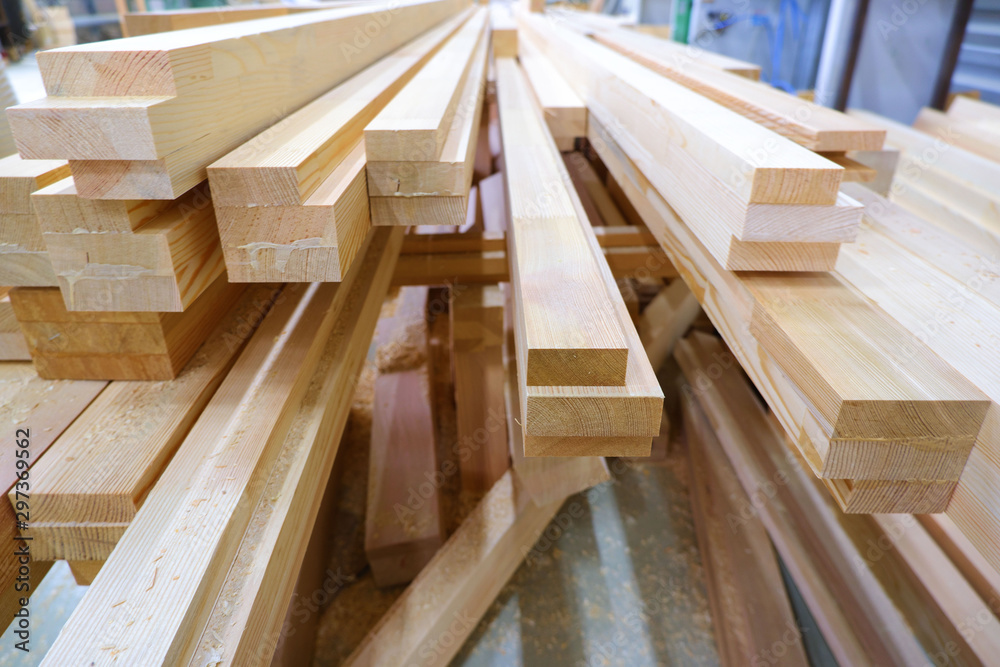 View from butt of stack of three-layer wooden glued laminated timber beams from pine finger joint spliced boards