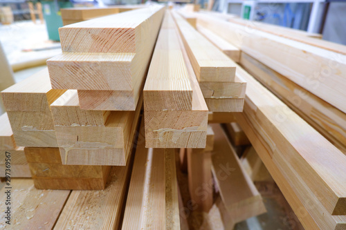 View from butt of stack of three-layer wooden glued laminated timber beams from pine finger joint spliced boards