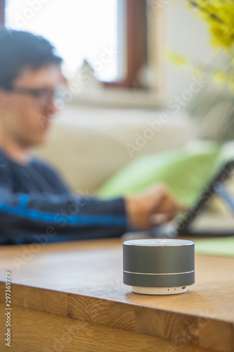 Smart ai speaker with child playing on tablet in the backround.  Smart home concept