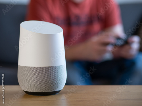 smart home voice activated speaker in lounge with gamer in background