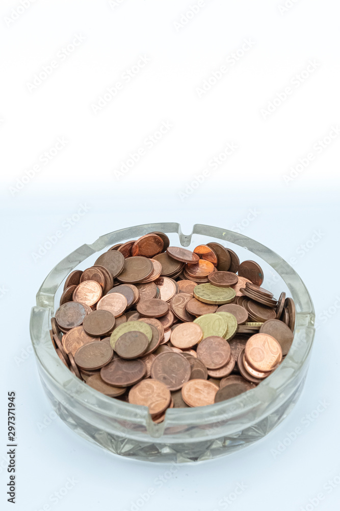 Euro cent coins in a glass ashtray. Financial concept. Euro cent coins in a glass ashtray. Financial concept.