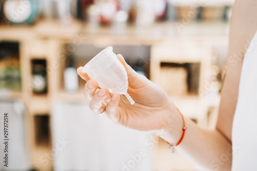 Woman hands holding menstrual cup in zero waste shop photo