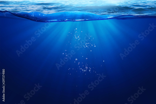 Deep Blue Sea Under Water Light Ray Through on Wavy Sea Surface  And Small Bubbles Under The Ocean Summber Concept Background photo