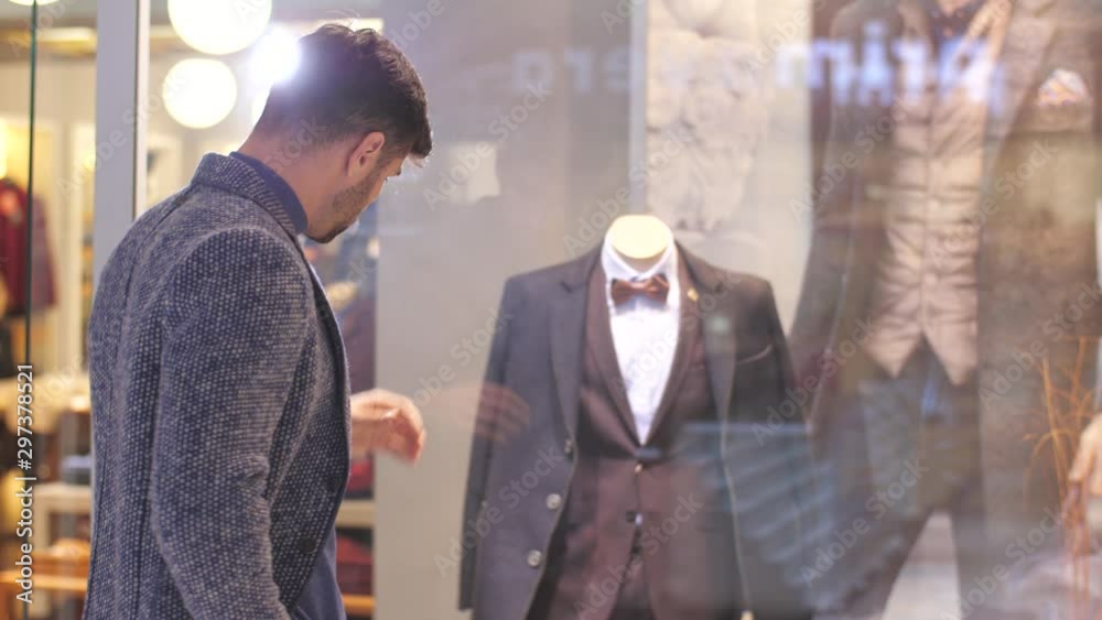 Man looking at suit in a shop window