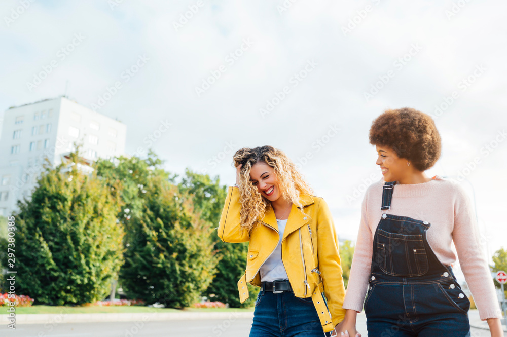 Stylish young women having friendly meeting walking in the street. LGTB concept