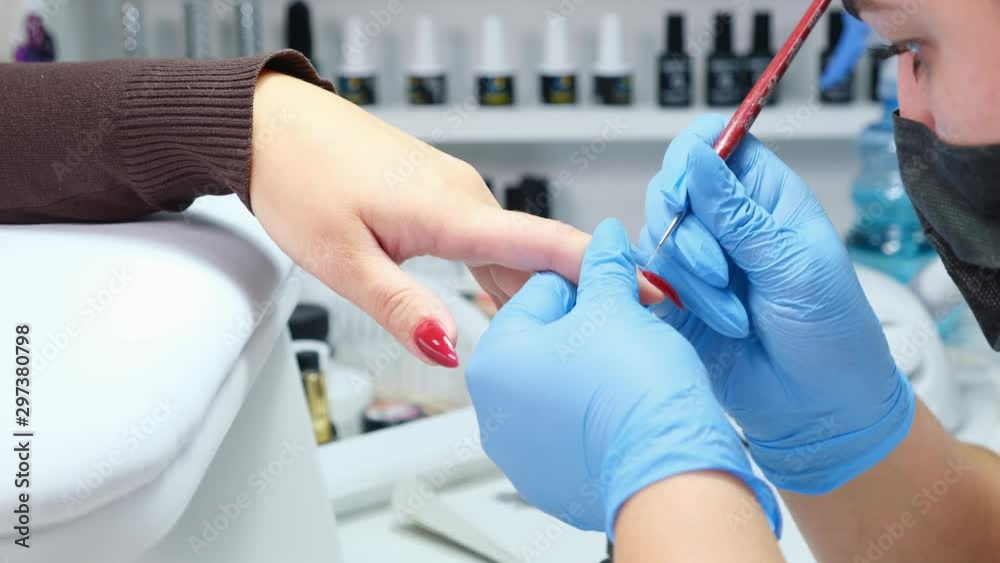 Manicurist is applying gel polish to the nails of a client in a beauty salon. Build up nails. Manicure Manicurist is applying gel polish to the nails of a client in a beauty salon. Build up nails. Manicure