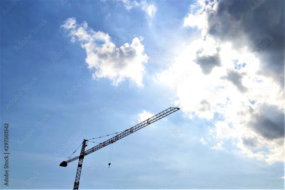 Construction crane tower against a blue sky, clouds Construction crane tower against a blue sky, clouds