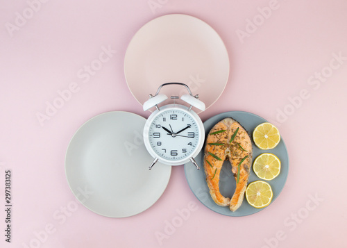 Intermittent fasting concept with empty colorful plates. Time to lose weight , eating control or time to diet concept.Healthy eating food low carb keto ketogenic diet. photo