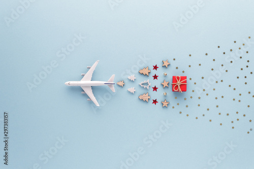 Christmas composition. Airplane flying in sky star gift bauble set top view background with copy space for your text. Flat lay.