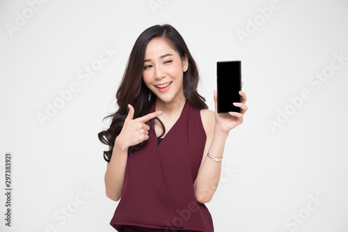 Portrait of beautiful Asian wowan showing or presenting mobile phone application on hand isolated over white background