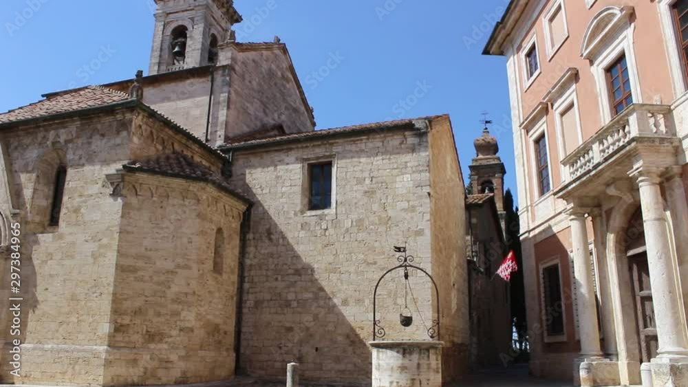 water well with a helmet swinging by the wind near the Collegiate Church of San Quirico D'Orcia and the bell tower, Siena, Tuscany, Italy. Tilt-Up Pan view, HD Video water well with a helmet swinging by the wind near the Collegiate Church of San Quirico D'Orcia and the bell tower, Siena, Tuscany, Italy. Tilt-Up Pan view, HD Video