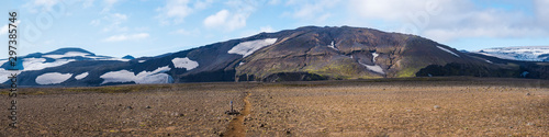 Panoramic Icelandic lava desert landscape with top of Eyjafjallajokull glacier and volcano, partialy covered in clouds. Iceland, Fimmvorduhals hiking trail. Summer sunny day.