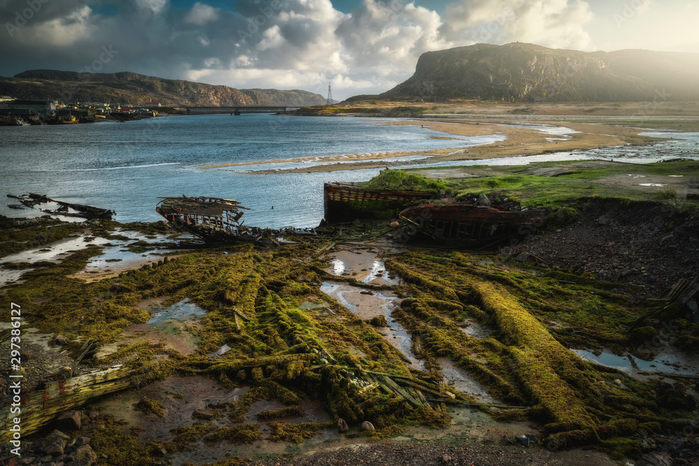 Obraz premium Abandoned ships cemetery at low tide near Teriberka village in Murmansk Region. Kola peninsula, Northern Russia