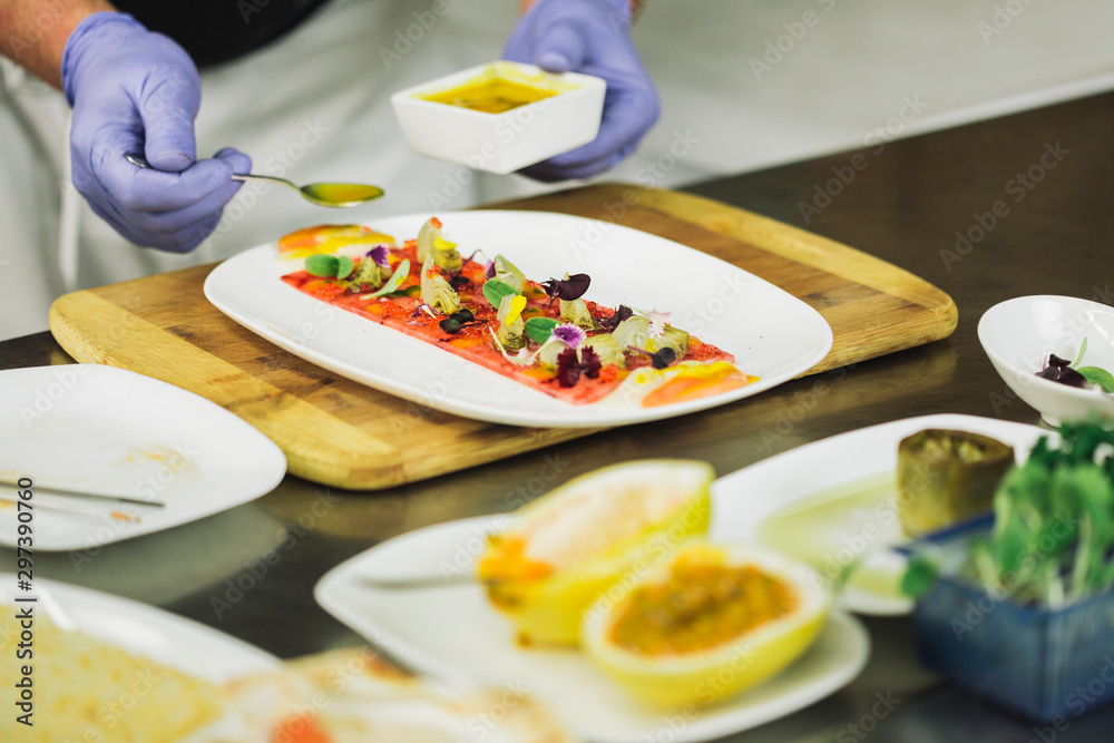 Chef in hotel or restaurant kitchen cooking, only hands, he is working on a new spanish tapa. Chef in hotel or restaurant kitchen cooking, only hands, he is working on a new spanish tapa.