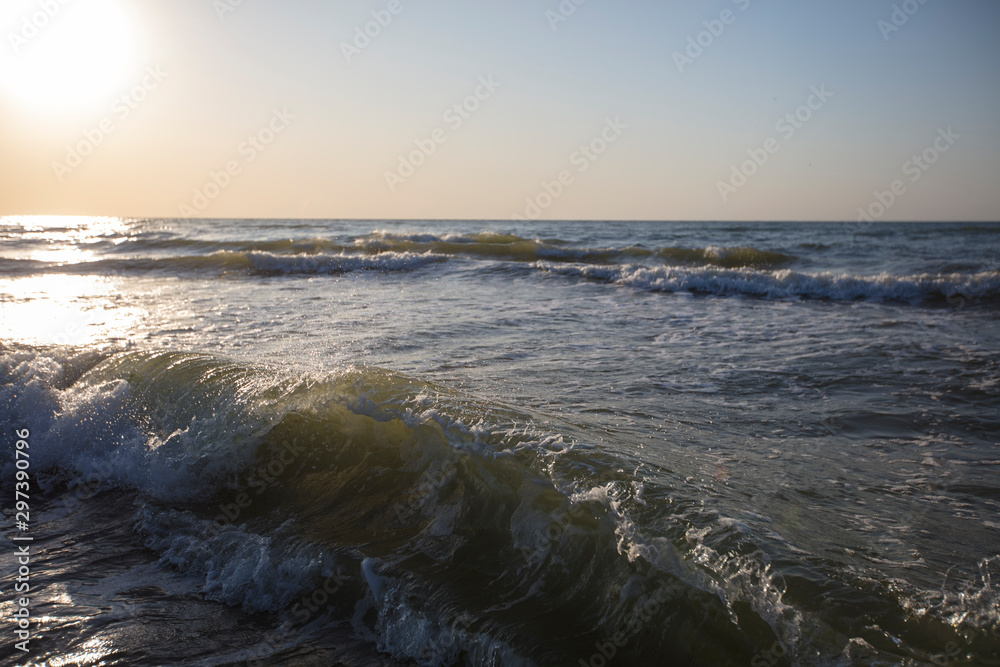 Seascape. The wave illuminated by the rising sun