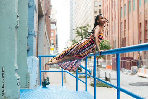 Dancer suspending legs midair while holding railing