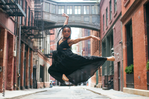 Dancer facing forward mid leap above ground