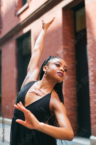 Dancer posing with right arm outstretched and left arm bent