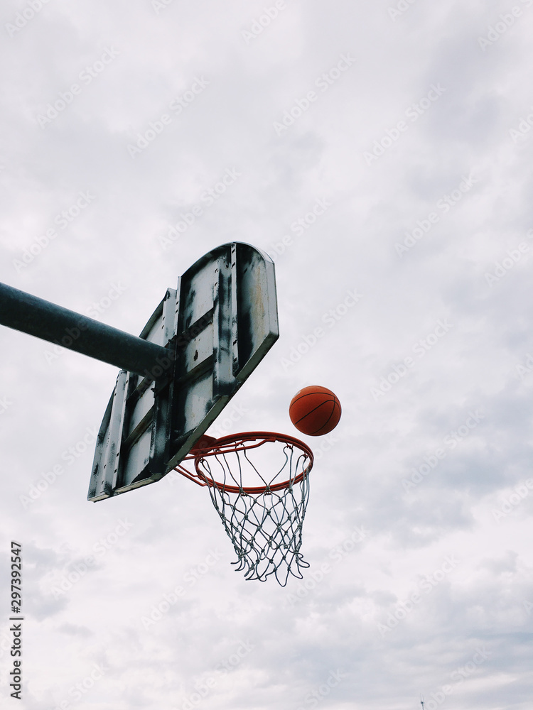 Low angle view of basketball falling through hoop