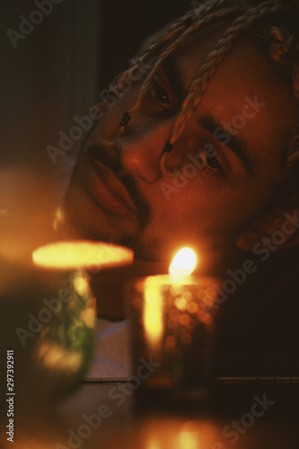 Selective focus of man with braids  in candle light