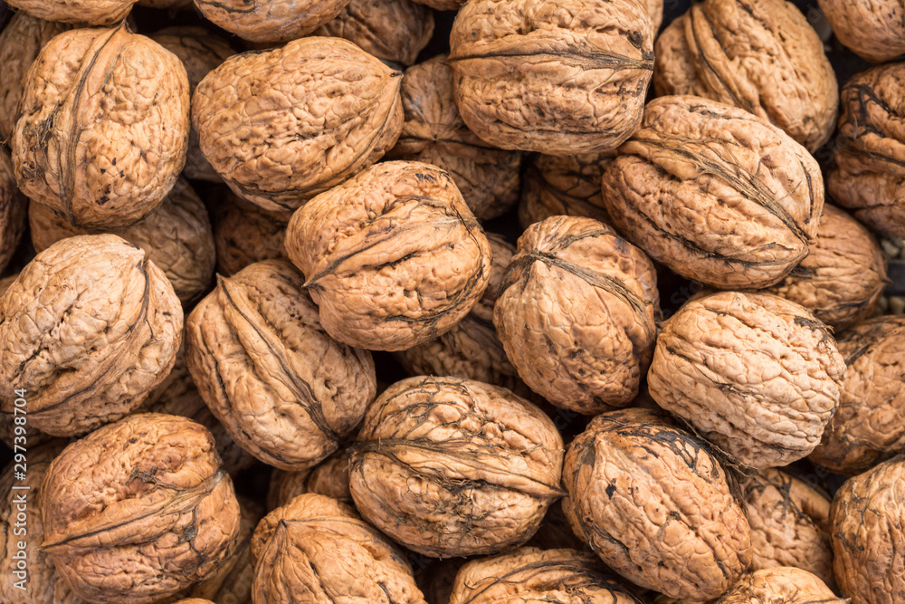 Walnut background, scattered pile of walnuts. Walnuts of Juglans regia. Walnut background, scattered pile of walnuts. Walnuts of Juglans regia.