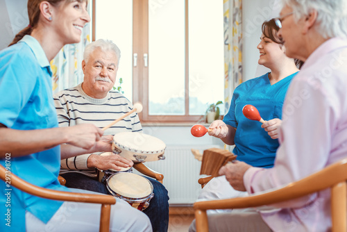 Seniors in nursing home making music with rhythm instruments