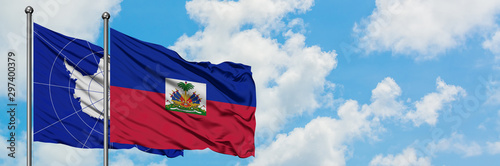 Obraz na płótnie Antarctica and Haiti flag waving in the wind against white cloudy blue sky together