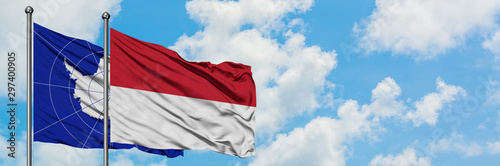 Antarctica and Indonesia flag waving in the wind against white cloudy blue sky together. Diplomacy concept, international relations.