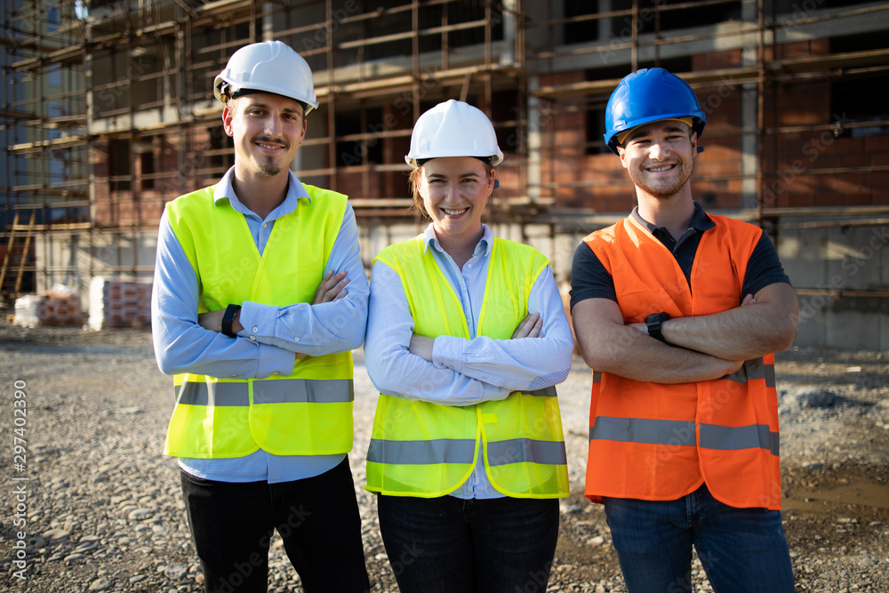 Group of construction workers on building site - obrazy, fototapety, plakaty 