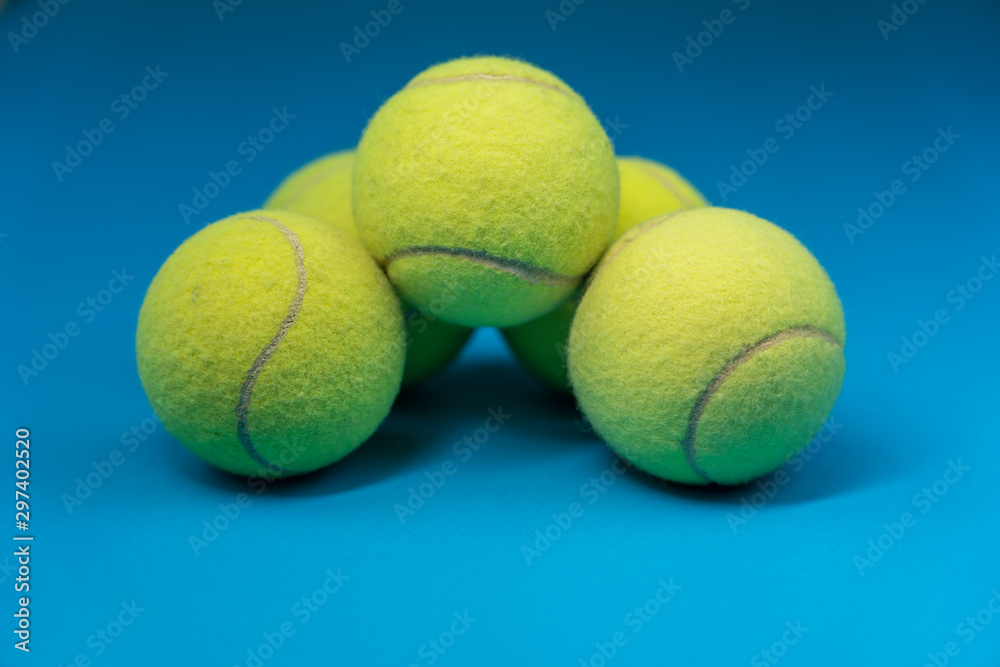 Cinco pelotas de tenis formando una casa sobre fondo azul, fotografía de  estudio para deportes y venta online foto de Stock | Adobe Stock