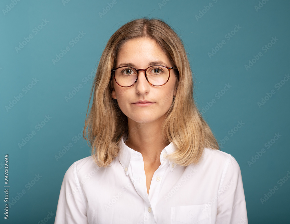 Portrait of a blonde businesswoman with glasses in front of blue background Portrait of a blonde businesswoman with glasses in front of blue background