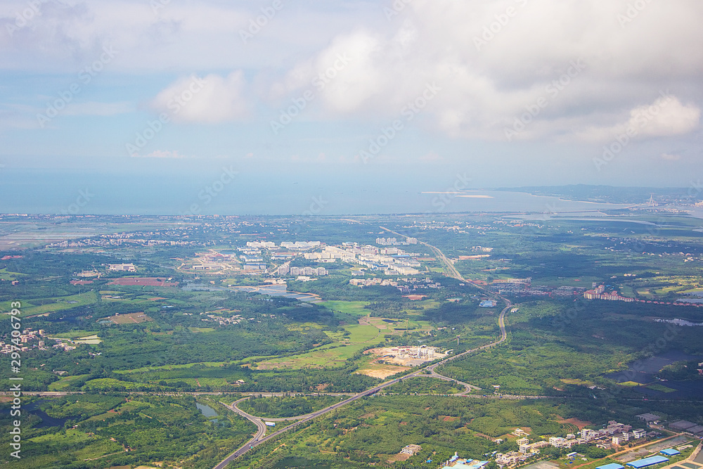 Aerial view on the beautiful exotic Hainan island, China. Clouds and fields seen from the airplane