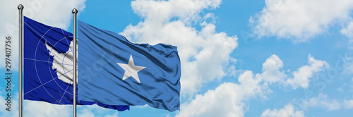 Antarctica and Somalia flag waving in the wind against white cloudy blue sky together. Diplomacy concept, international relations.