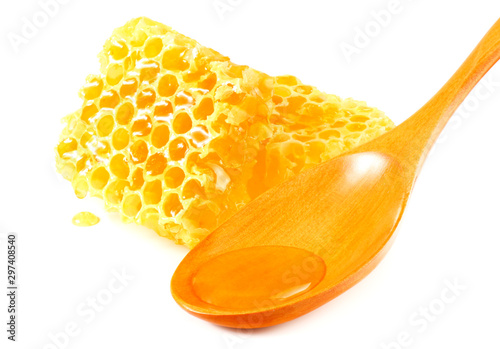 Honeycomb with wooden spoon and honey isolated on white background