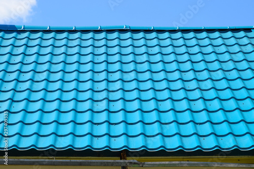 Turquoise metal tiles on roof of the house. Modern roofing materials