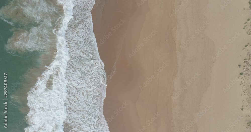 Waves crashing on beautiful empty beach, aerial birds eye view Waves crashing on beautiful empty beach, aerial birds eye view