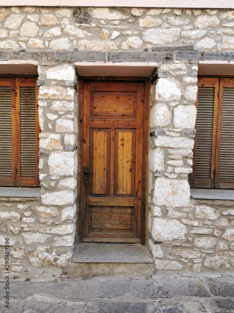Brown vintage rustic wooden door with stone wall