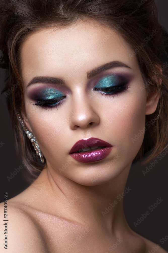 Beautiful young girl with evening colorful makeup and half closed eyes. Color lipstick with metall effect. Beautiful young girl with evening colorful makeup and half closed eyes. Color lipstick with metall effect.